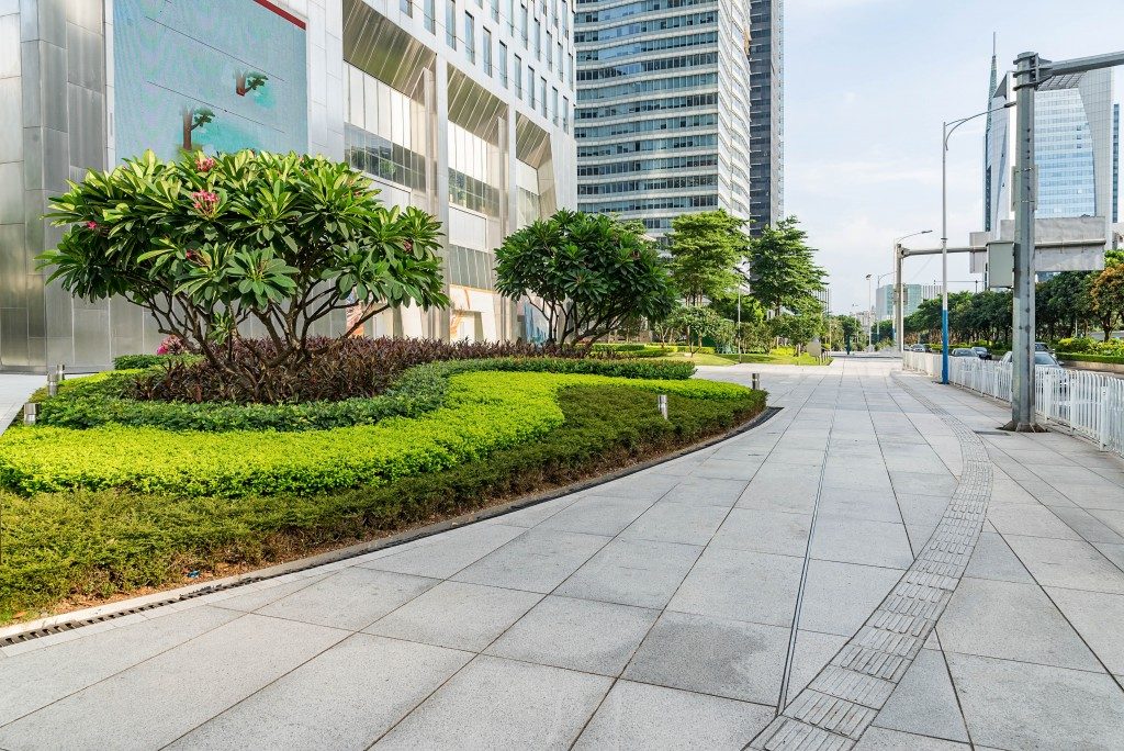 Buildings in city with green landscape