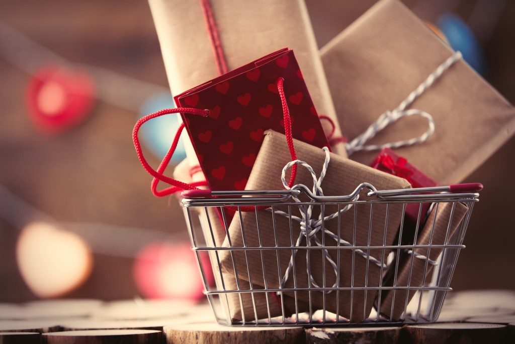 Shopping basket and gifts for Valentine's or Christmas with color bokeh on background