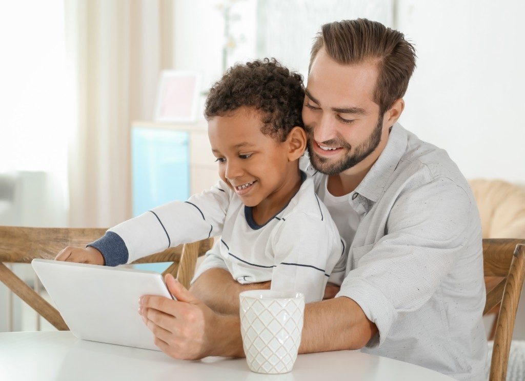 Man and kid using a tablet together