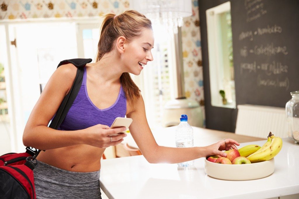 woman picking out fruit from the bowl at the gym