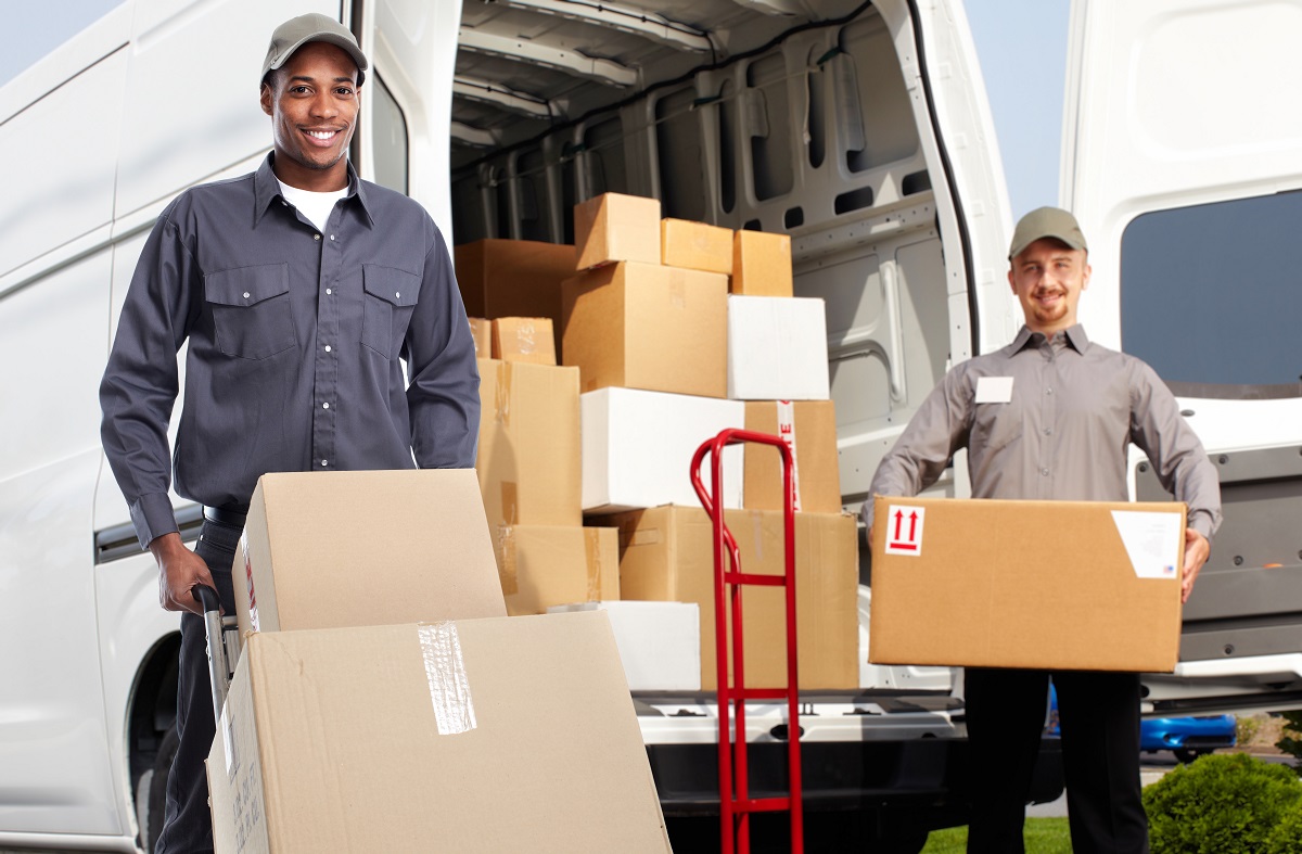 Delivery men in uniform carrying boxes