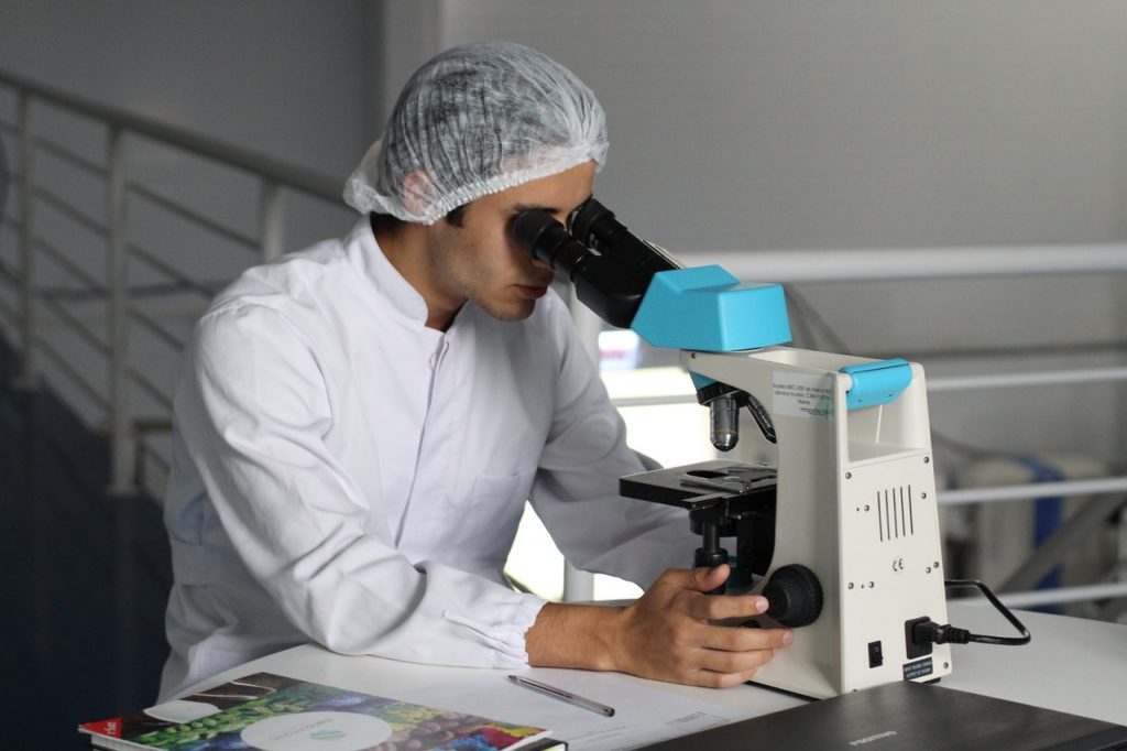 man looking through microscope