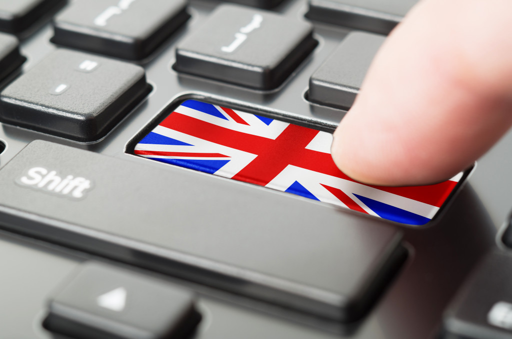 Finger pressing United Kingdom key on a black keyboard