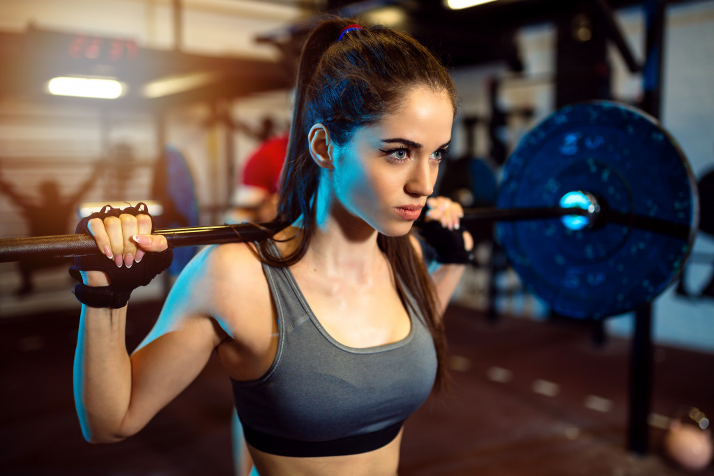 woman wearing work out clothes lifting a barbell