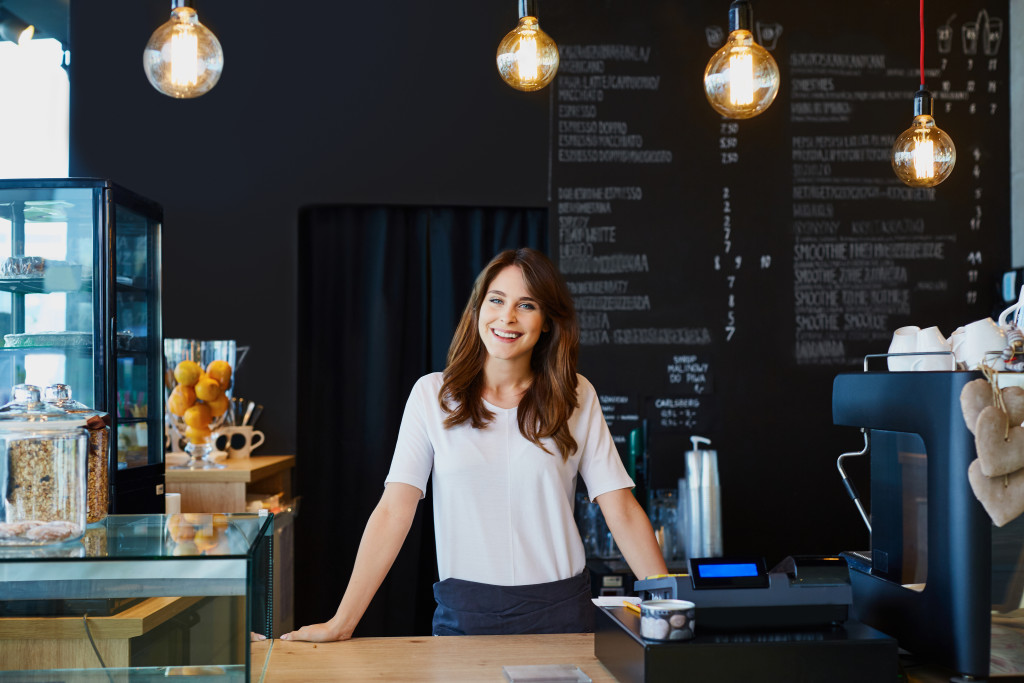 Small business owner standing behind the counter of her cafe.