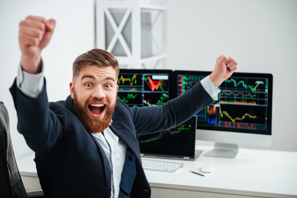 A cheerful businessman raising his hands