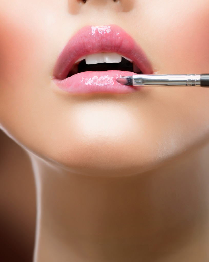 a woman applying lip product