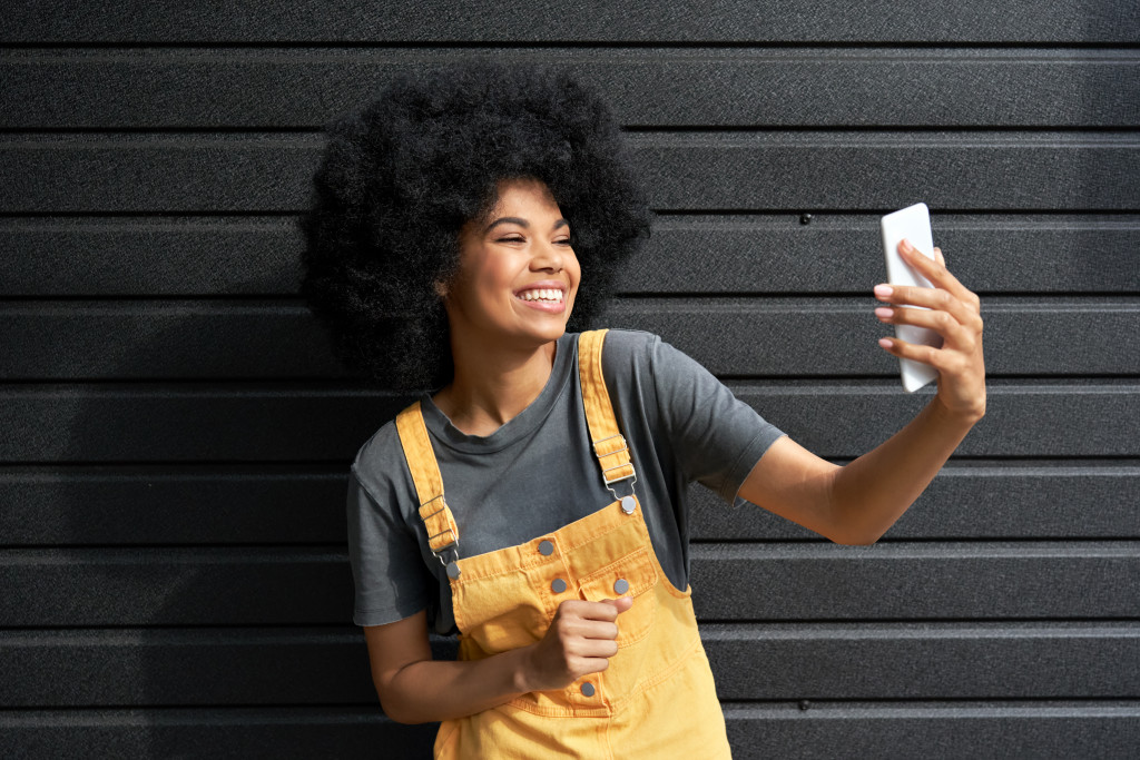 A happy woman recording a vlog using her mobile phone