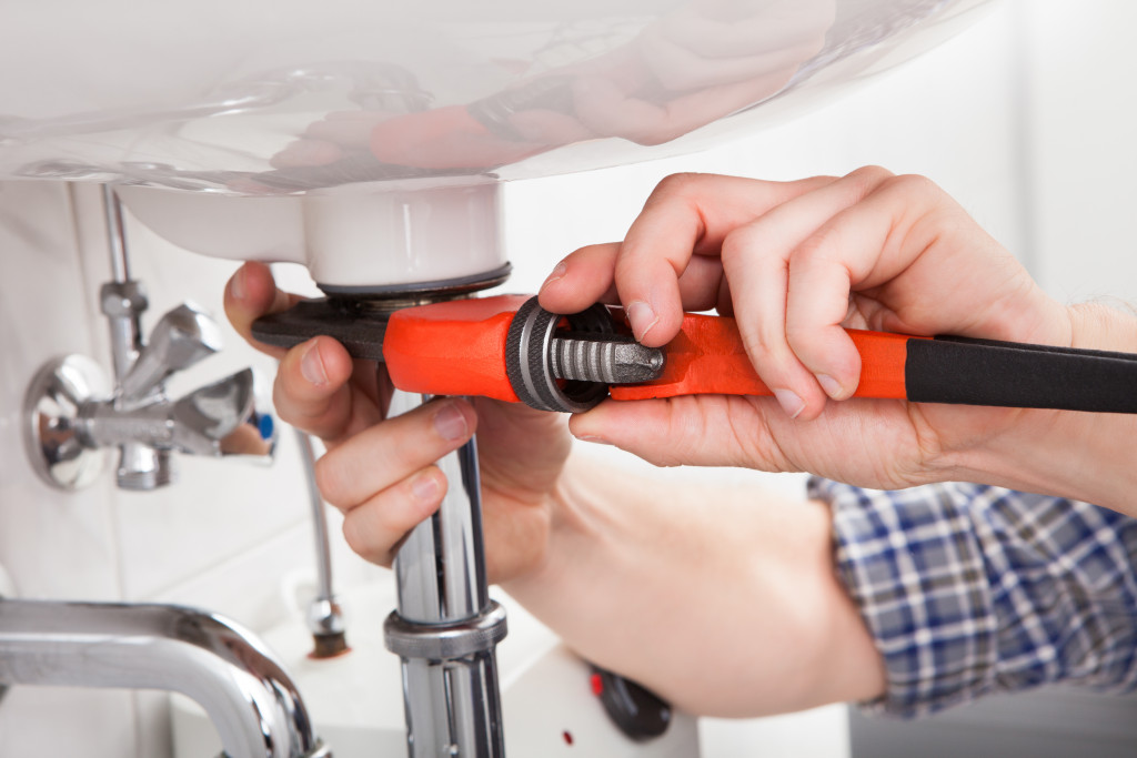 A commercial plumber fixing office sink leaks