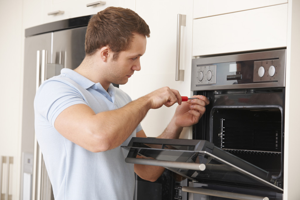 A Man Fixing Oven