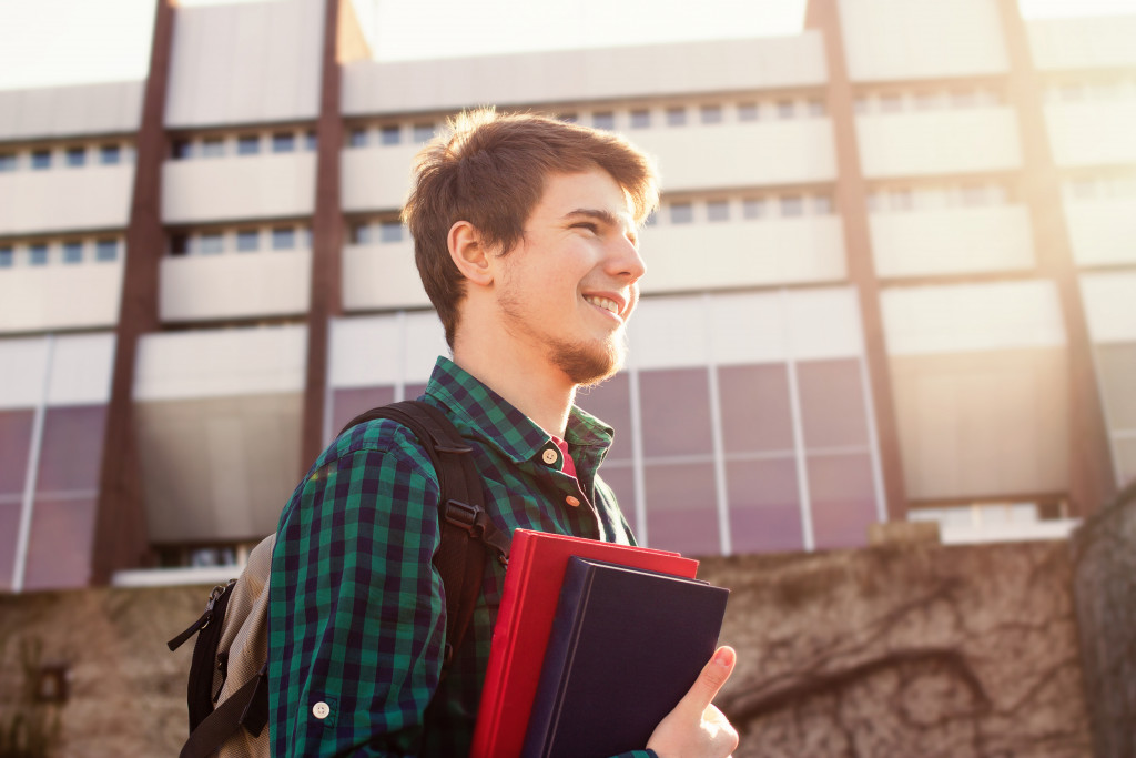 male student in the university carrying school items