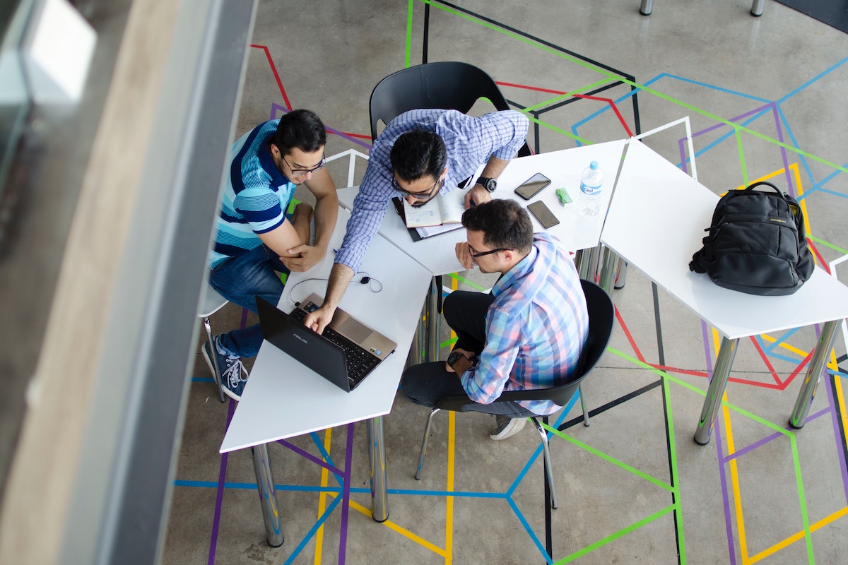 Top-view Photo of 3 Men in Front of Laptop