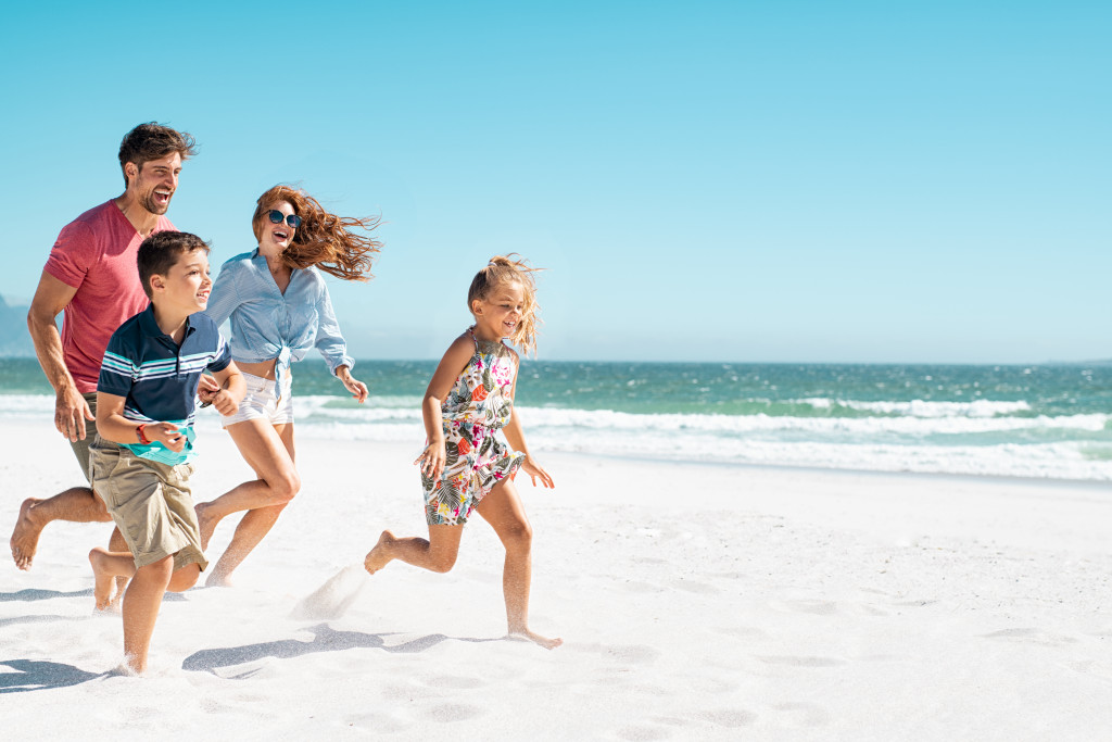 Small family having fun in the beach during summer.