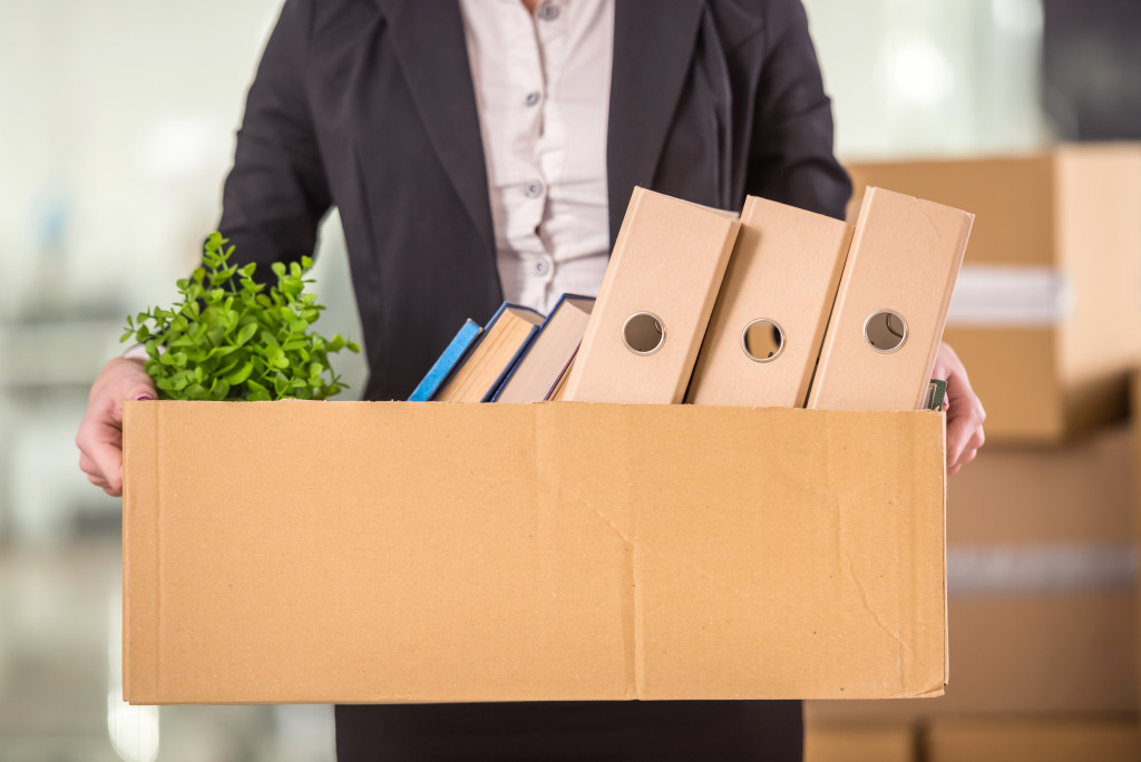 Young business executive carrying a box of belongings after getting terminated.