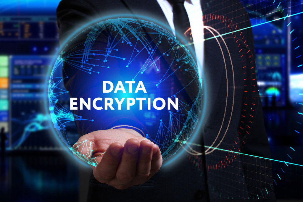A businessman holding a blue sphere with the words DATA ENCRYPTION