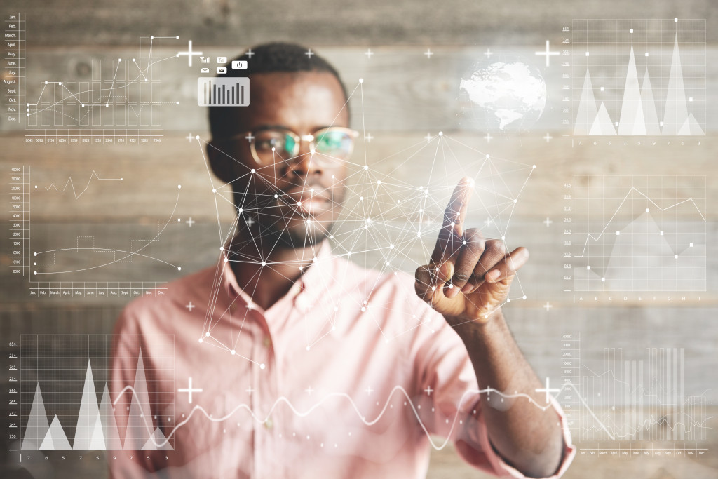 Handsome African American businessman in shirt touching screen interface