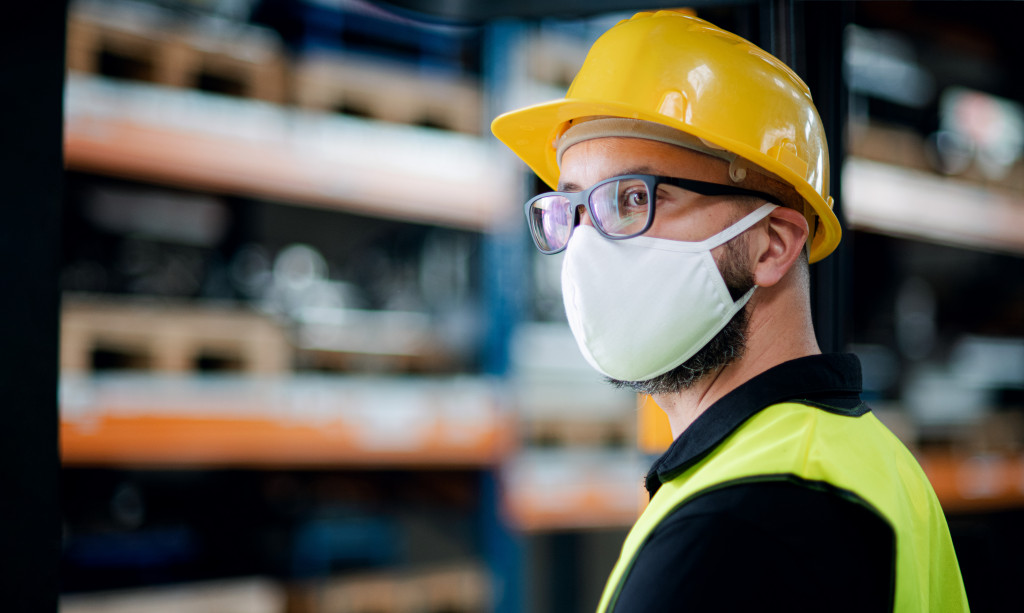 man wearing hard hat and face mask in industrial factory