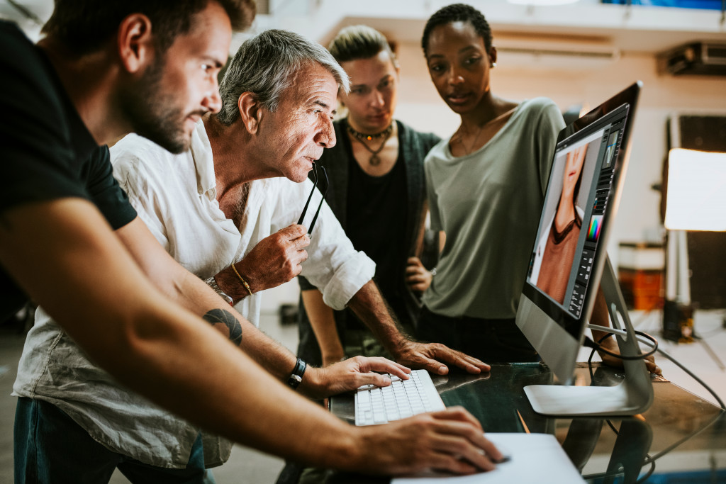 a group of people watching a man edit a photo