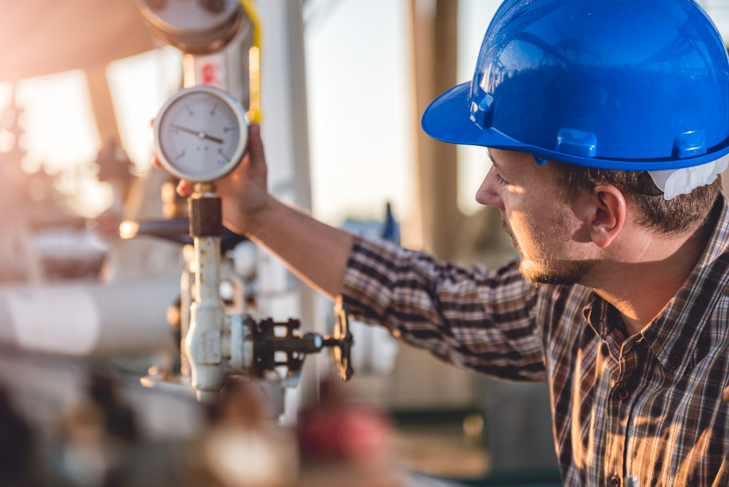 male expert checking the gauge on a natural gas business equipment