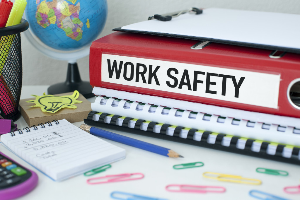 red binder labeled work safety with planning tools in the office desk