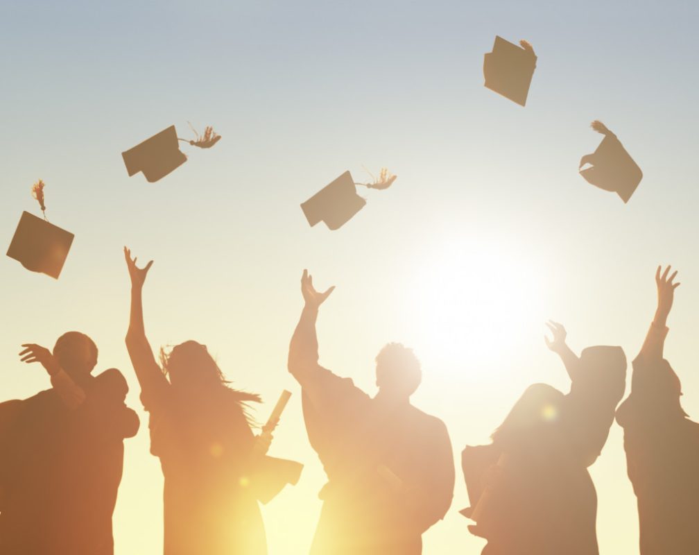 graduates throwing graduation cap