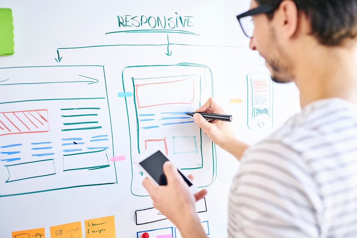 man designing his website on a white board