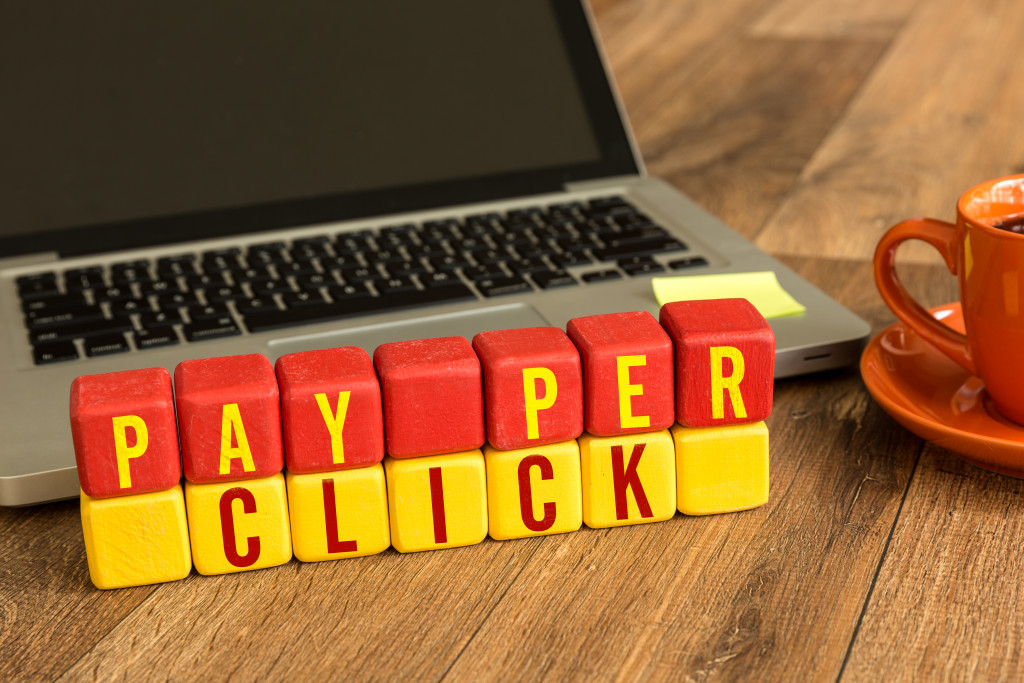 Pay-per-click spelled out using letter cubes in front of a laptop