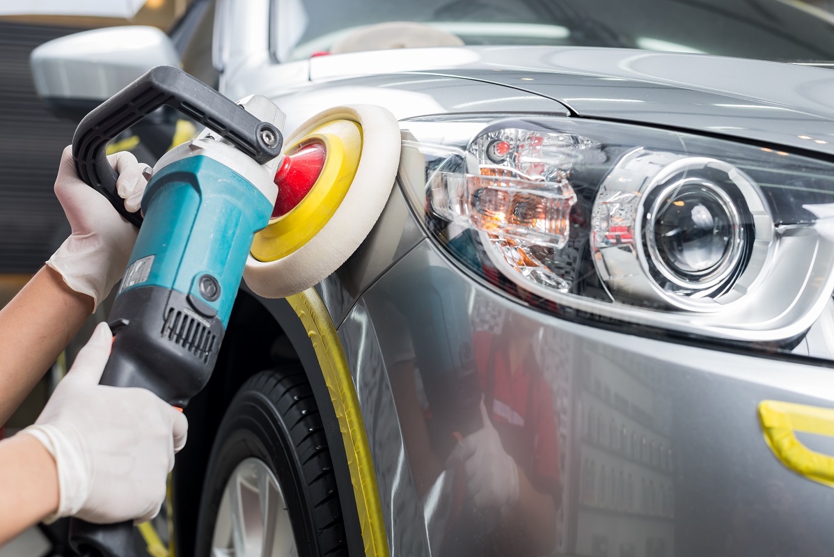 man using auto detailing machine to polish a silver car