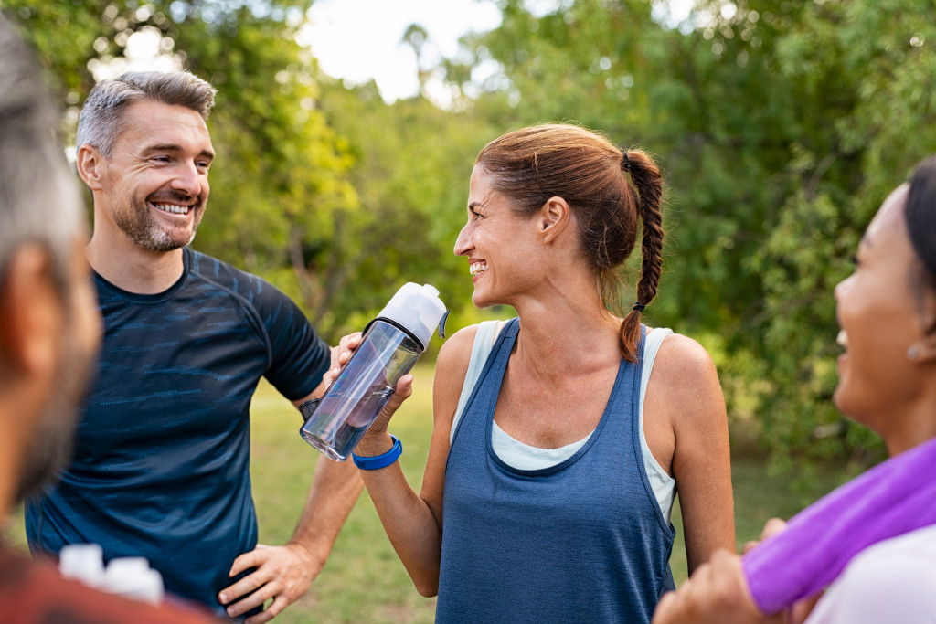 woman drink water with friends after workout